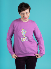 Tilly Walnes wears an orchid colour Billie sweatshirt with 'Stay Home and Sew' scissors transfer, made using Tilly and the Buttons' Billie sweatshirt kits.