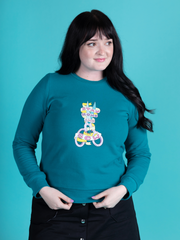 Abi Dyson wears a peacock colour Billie sweatshirt with 'Stay Home and Sew' scissors transfer, made using Tilly and the Buttons' Billie sweatshirt kits.