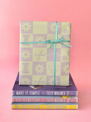 Gift wrapped book standing on top of three Tilly and the Buttons books