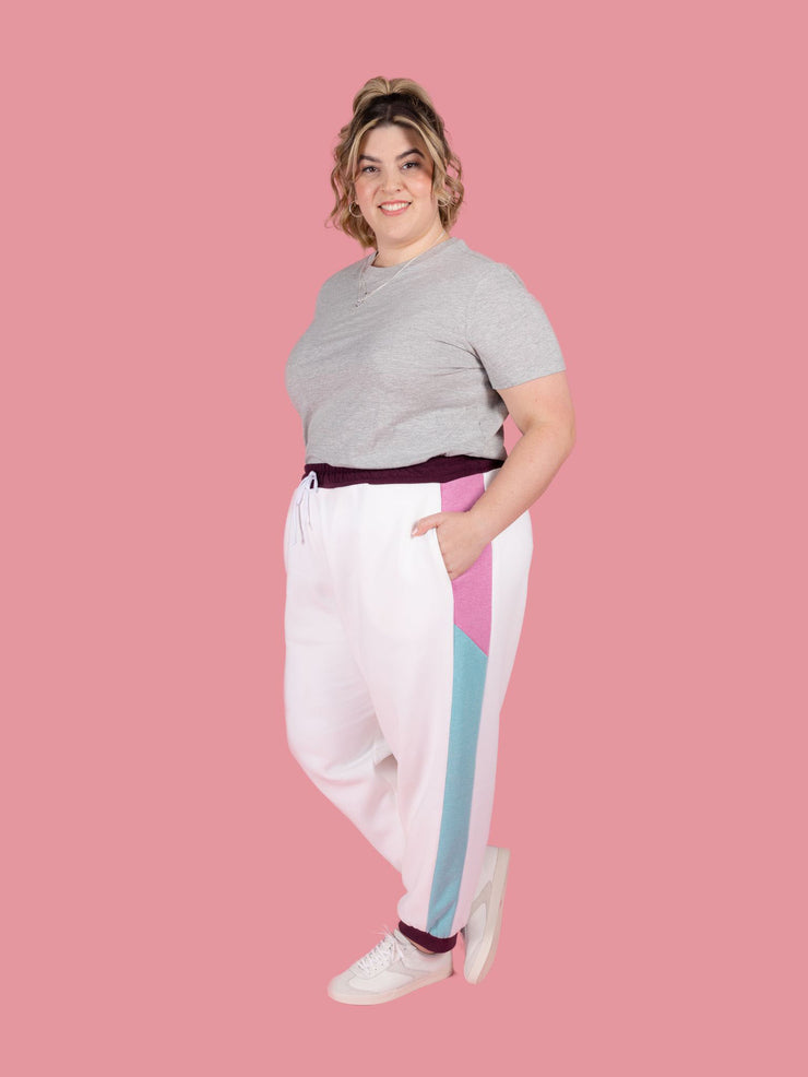 Plus size model wears Cece joggers sewing pattern from Tilly and the Buttons in white with colour block side panel and pockets