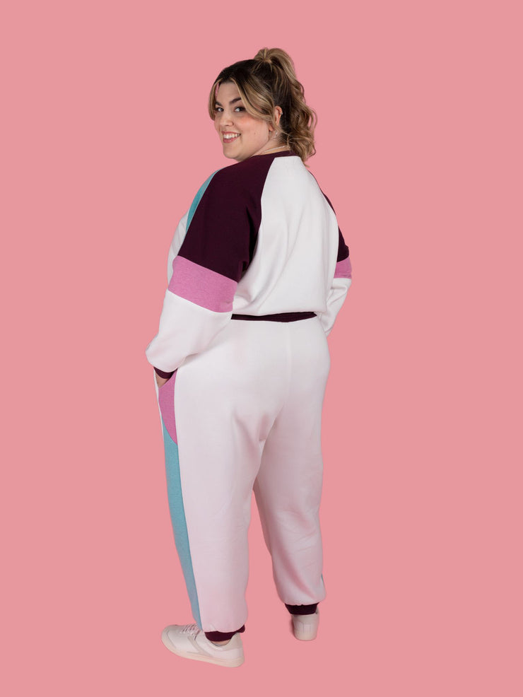 Back view of plus size model wearing Cece joggers sewing pattern from Tilly and the Buttons in white with colour block side panel and pockets