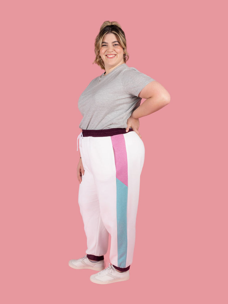 Plus size model wears Cece joggers sewing pattern from Tilly and the Buttons in white with colour block side panel and pockets