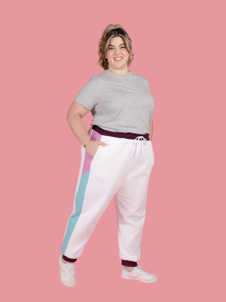 Plus size model wears Cece joggers sewing pattern from Tilly and the Buttons in white with colour block side panel and pockets