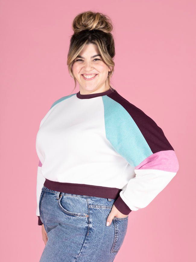 Model wearing the Tilly and the Buttons raglan sleeve sweatshirt in the colour block version, highlighting the stylish contrast of colours on the side of this versatile sewing pattern.