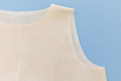 Calico toile of a sleeveless top on a blue background