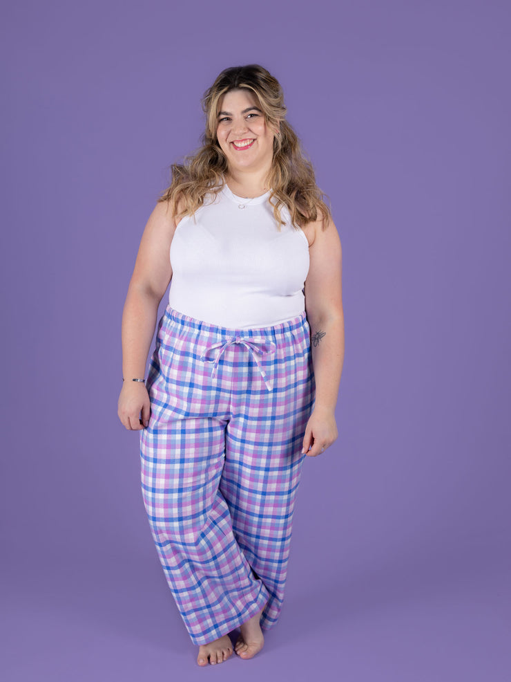 Model wearing a white tank top and purple plaid Jaimie pyjamas against a purple background