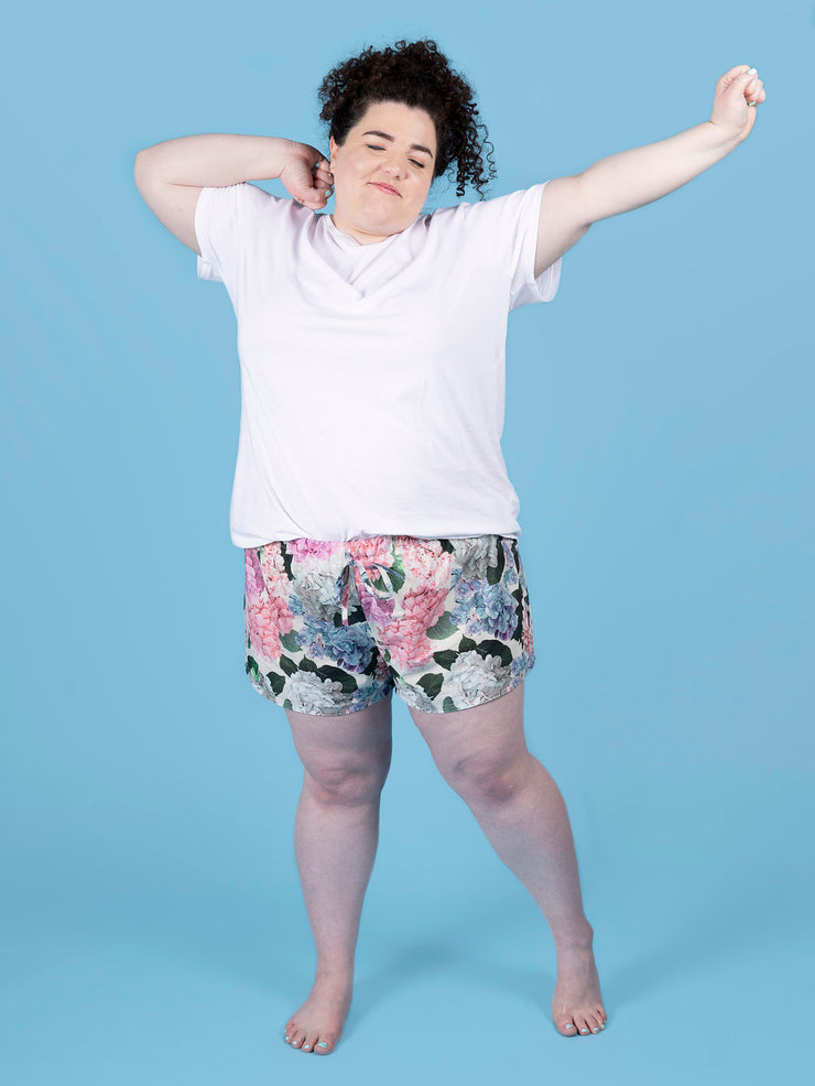 Model wearing a white t-shirt and floral Jaimie pj shorts on a blue background
