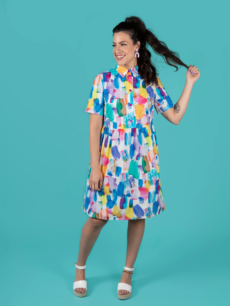 Woman wearing a colourful Lyra dress against a teal background