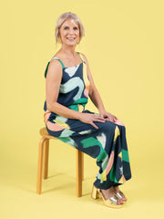 Model sitting down wearing a faux jumpsuit in a bold brushstroke print. The look was created with a matching top and trouser set, made using the Esti co-ord sewing pattern.