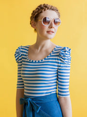 Model with sunglasses wears blue stripe jersey top with ruched sleeves