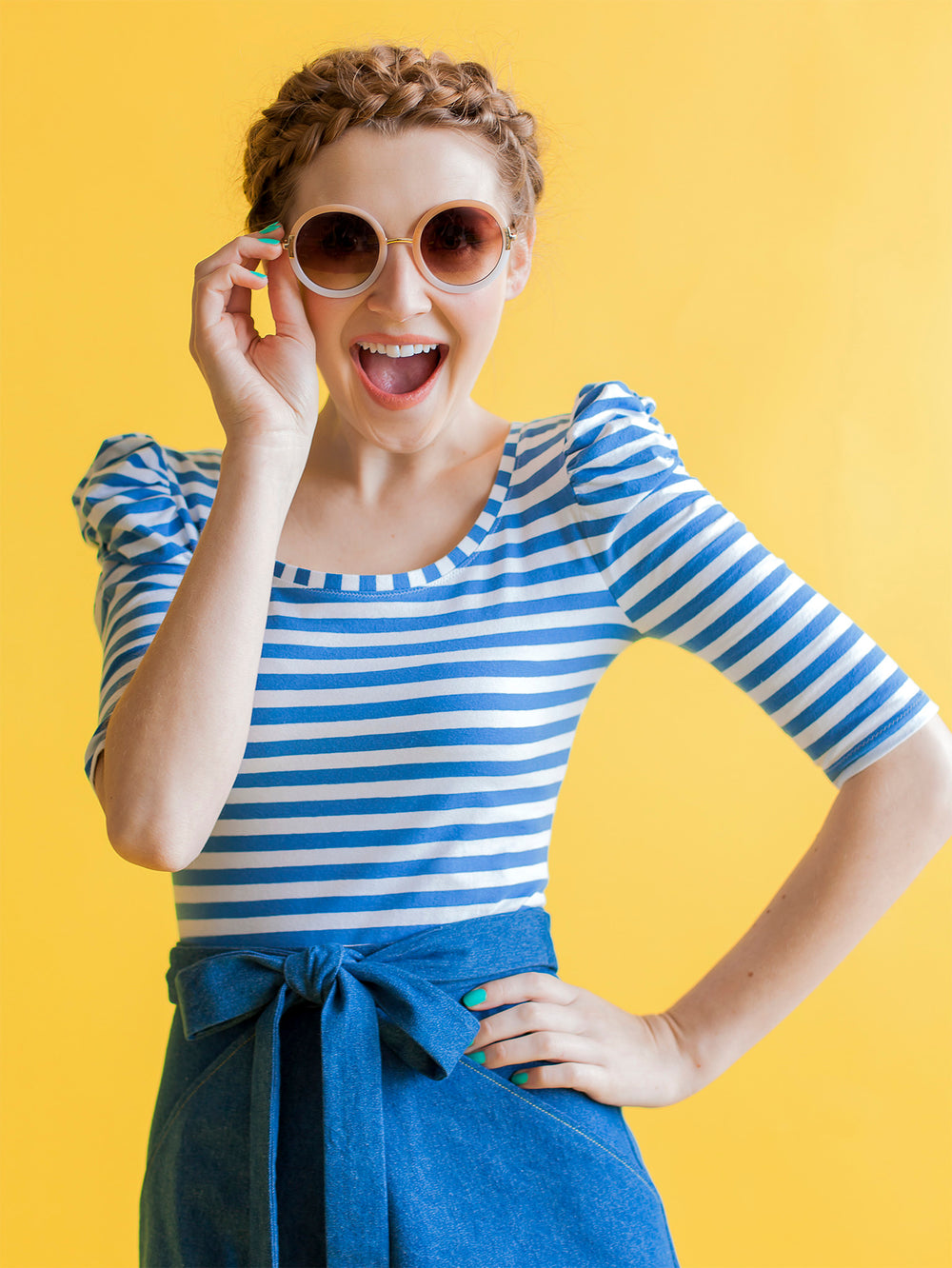 Model with sunglasses wears blue stripe jersey top with ruched sleeves