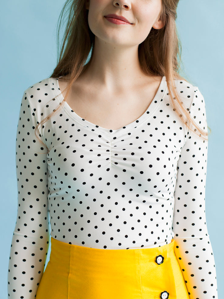 Model wearing polka dot jersey top with sweetheart neckline