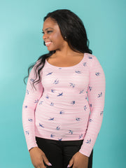 Model wearing a pink and white stripe jersey top with round neckline and long sleeves