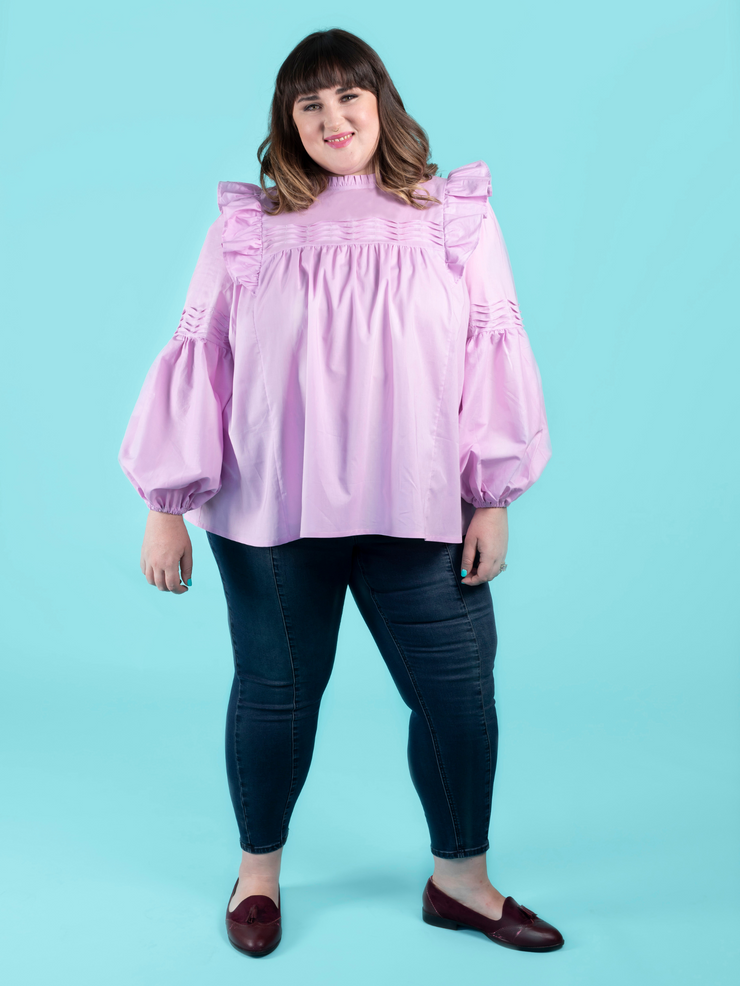 Model wearing a lilac blouse with tuck details, worn with dark blue jeans, made using the Marnie sewing pattern in cotton lawn.