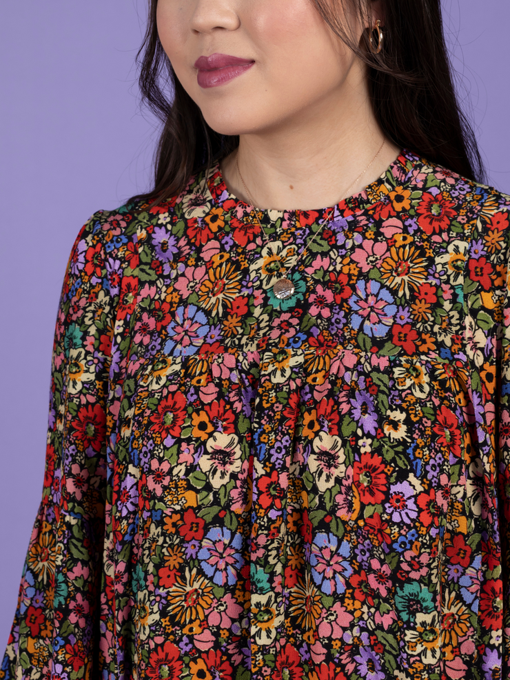 Close up of model wearing a floral mini dress, made using the Marnie sewing pattern in viscose crepe.