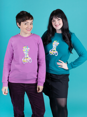  Tilly Walnes and Abi Dyson wear matching Billie sweatshirts with 'Stay Home and Sew' scissors transfer, made using Tilly and the Buttons' Billie sweatshirt kits. Tilly's sweatshirt is an orchid colour, Abi's is a peacock colour.